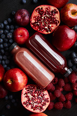 Image showing Mix of fresh red and black fruits. With botteled fresh juices