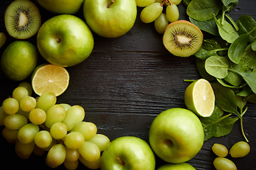 Image showing Mixed green fruits and vegetables placed on black wooden table