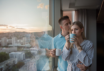 Image showing young couple enjoying evening coffee by the window