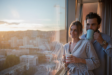 Image showing young couple enjoying evening coffee by the window