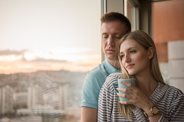 Image showing young couple enjoying evening coffee by the window