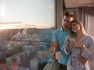 Image showing young couple enjoying evening coffee by the window