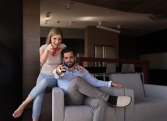 Image showing Young couple on the sofa watching television