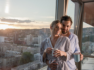 Image showing young couple enjoying evening coffee by the window