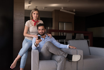 Image showing Young couple on the sofa watching television