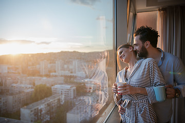 Image showing young couple enjoying evening coffee by the window