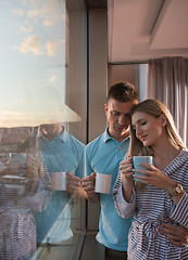 Image showing young couple enjoying evening coffee by the window