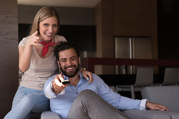 Image showing Young couple on the sofa watching television