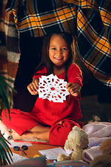 Image showing Beautiful girl holding her hands with snowflakes from the paper