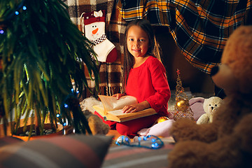 Image showing happy girl reading a book in the winter