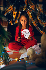 Image showing Beautiful girl holding her hands with snowflakes from the paper