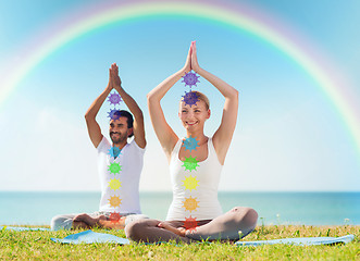 Image showing couple doing yoga in lotus pose with seven chakras