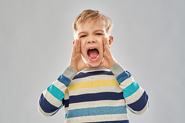 Image showing angry little boy in striped pullover screaming