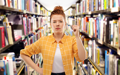 Image showing serious redhead student girl warning at library