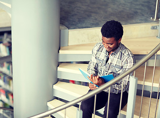 Image showing african student boy or man reading book at library