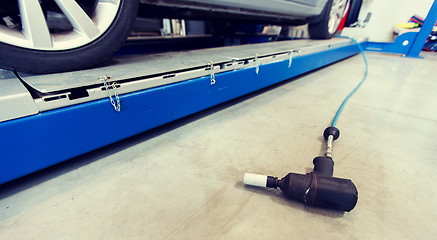 Image showing screwdriver and car at tire shop