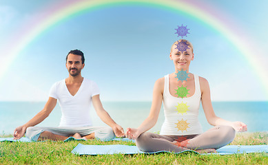 Image showing couple doing yoga in lotus pose with seven chakras