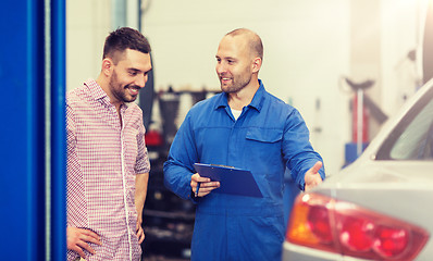 Image showing auto mechanic with clipboard and man at car shop