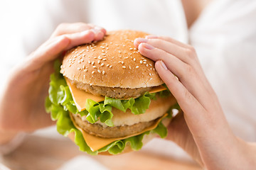 Image showing close up of woman holding hamburger