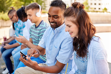 Image showing friends with smartphones and tablet pc in city