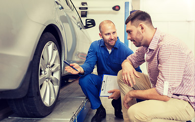 Image showing auto mechanic with clipboard and man at car shop