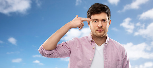 Image showing bored man shooting himself by finger gun gesture