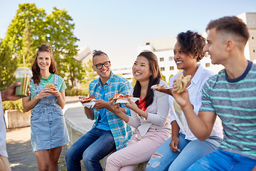 Image showing friends eating sandwiches or burgers in park