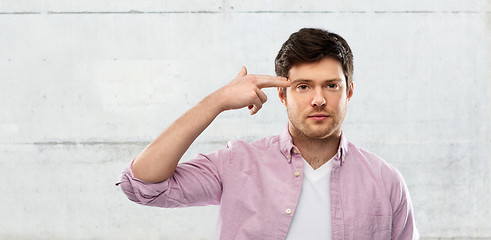 Image showing bored man shooting himself by finger gun gesture