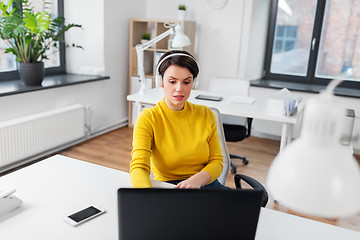 Image showing businesswoman with headphones and laptop at office