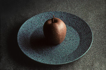 Image showing Granite-like sculpture of apple on a plate