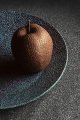 Image showing Granite-like sculpture of apple on a plate