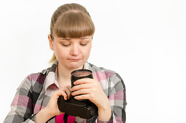 Image showing The girl looks sadly at the front lens of the lens on the camera