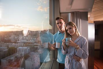 Image showing young couple enjoying evening coffee by the window