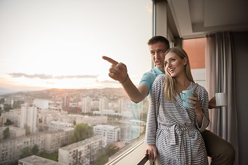 Image showing young couple enjoying evening coffee by the window