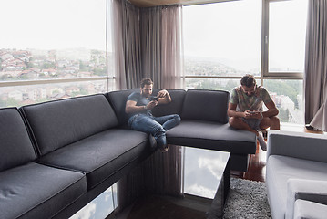 Image showing two young men using a mobile phones  at home