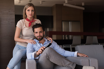 Image showing Young couple on the sofa watching television