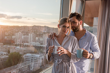 Image showing young couple enjoying evening coffee by the window