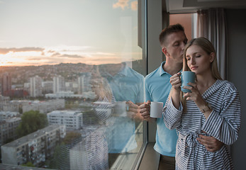 Image showing young couple enjoying evening coffee by the window