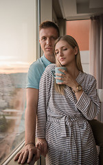 Image showing young couple enjoying evening coffee by the window