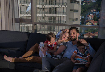 Image showing happy young couple spending time with kids at home