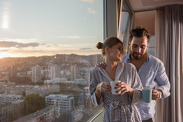 Image showing young couple enjoying evening coffee by the window