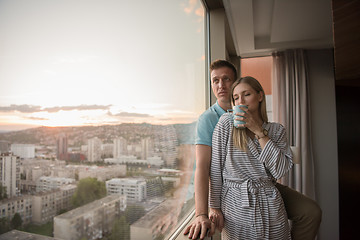 Image showing young couple enjoying evening coffee by the window