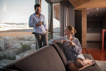 Image showing young couple enjoying evening coffee by the window