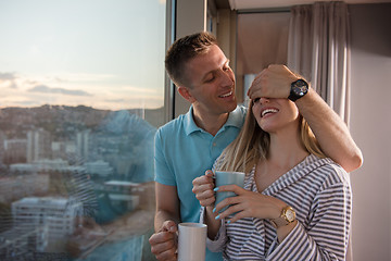 Image showing young couple enjoying evening coffee by the window