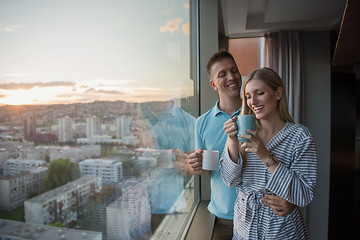 Image showing young couple enjoying evening coffee by the window