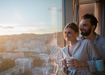 Image showing young couple enjoying evening coffee by the window