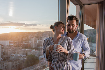 Image showing young couple enjoying evening coffee by the window