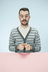 Image showing Serious business man with mobile phone sitting at the table