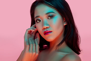 Image showing High Fashion model woman in colorful bright lights posing in studio