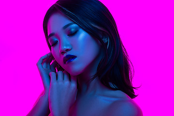 Image showing High Fashion model woman in colorful bright lights posing in studio